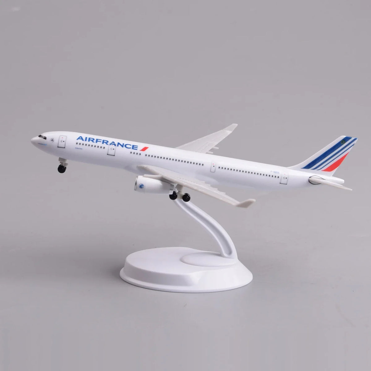 Air France A330 desk model in a climbing takeoff pose on its display stand, side view