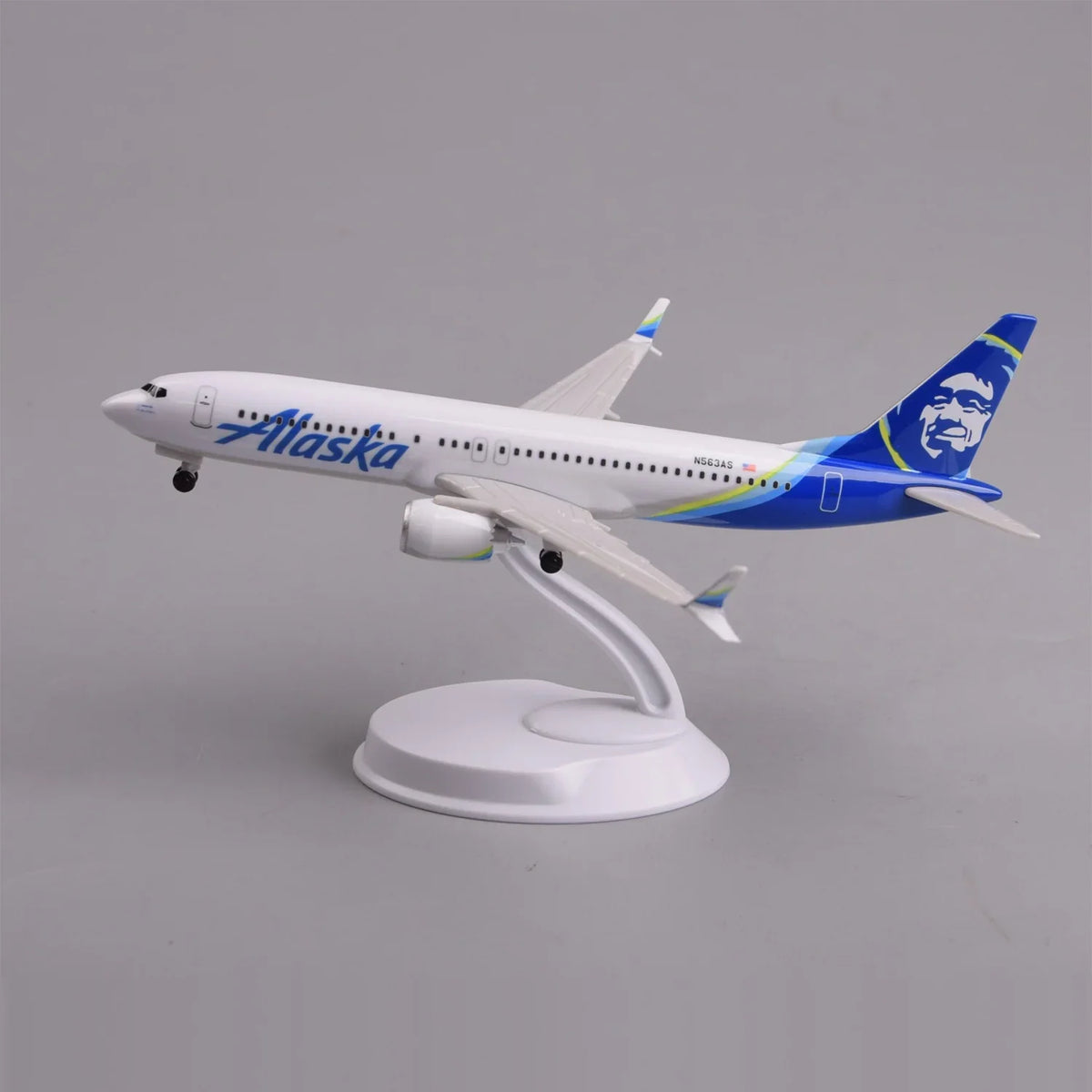Alaska Airlines 737 MAX 8 desk model in a climbing takeoff pose on its display stand, side view