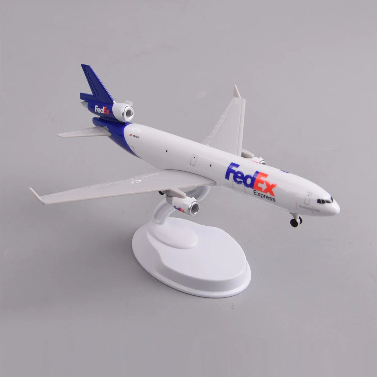 FedEx MD-11 freighter model showing the tri-jet tail engine and swept wings, rear three-quarter view on display stand