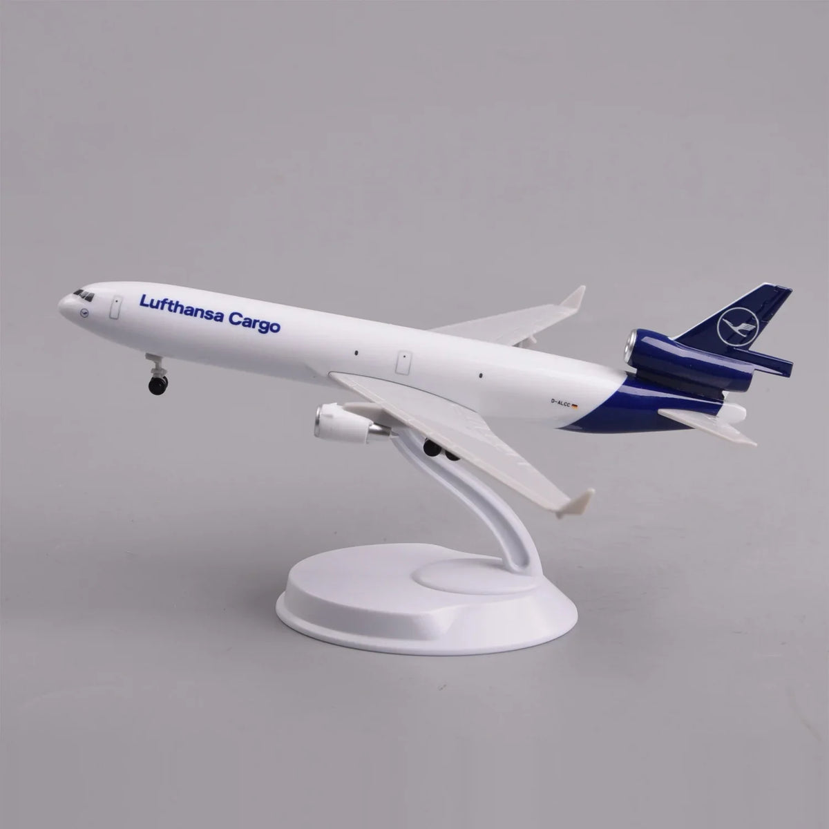 Lufthansa Cargo MD-11 desk model in a climbing takeoff pose on its display stand, side view
