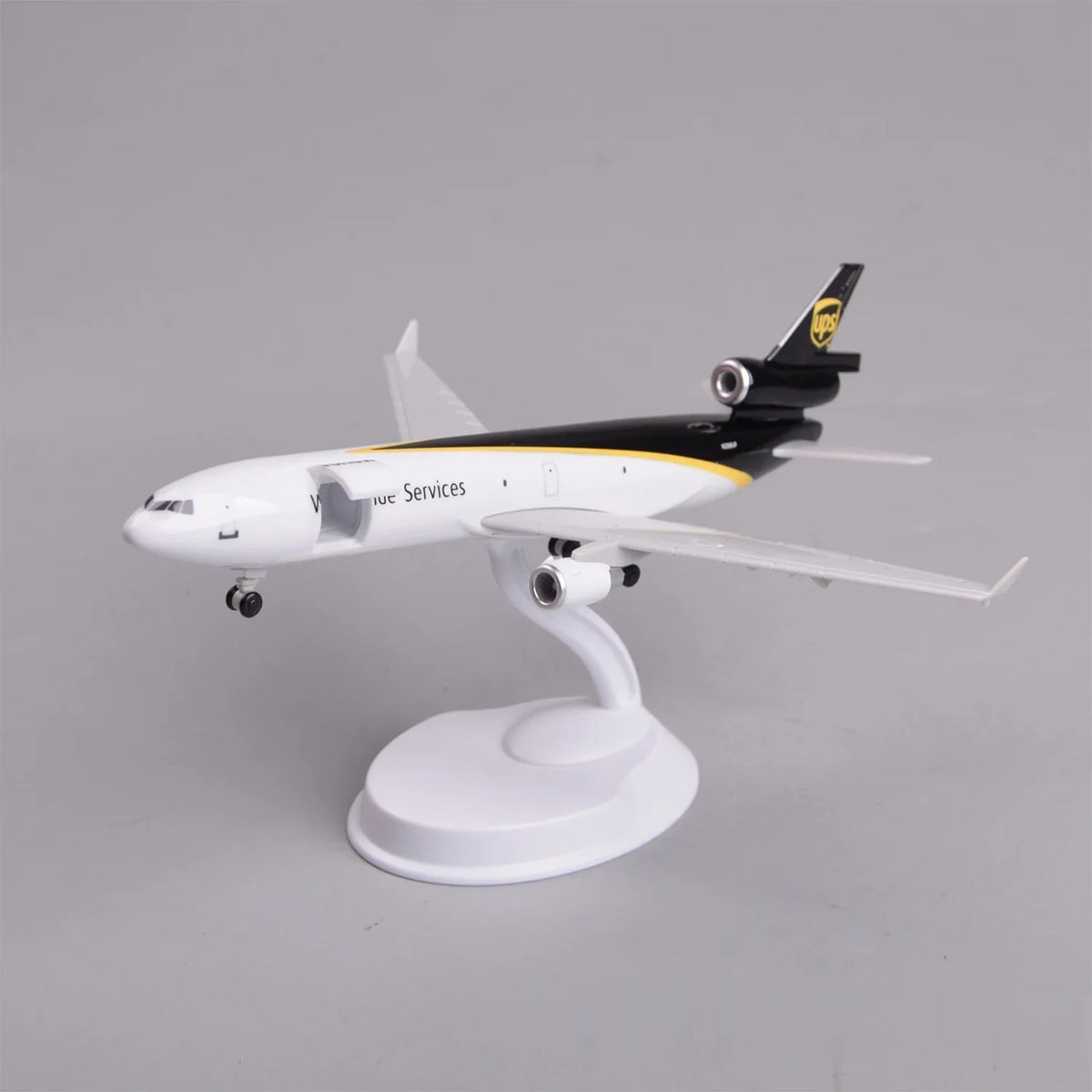 UPS MD-11 model plane in brown and gold livery mounted on its display stand, view from the nose